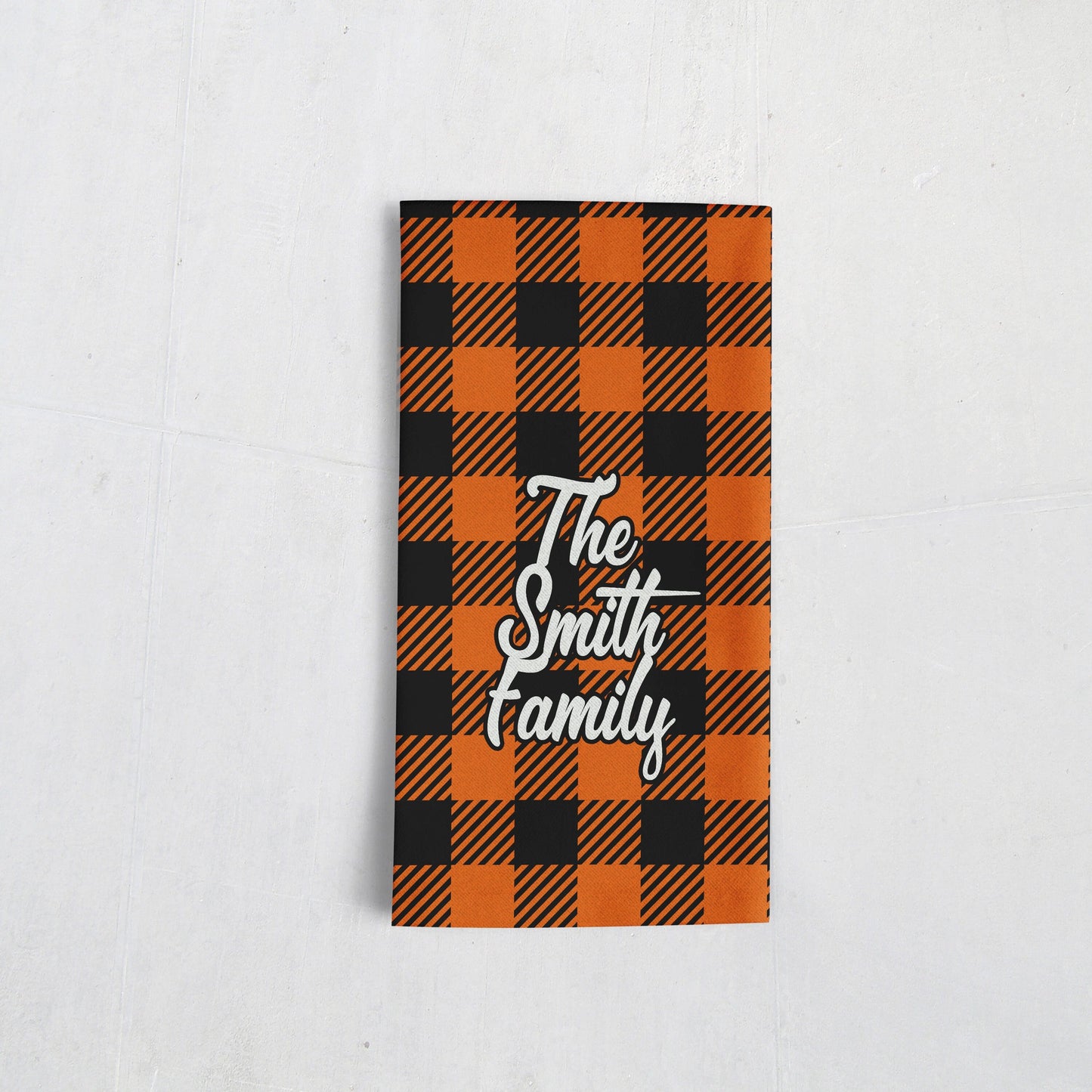 An orange and black gingham towel with customized family name