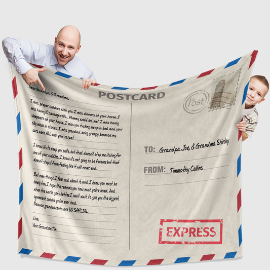 A man and a kid holding a customized air mail letter designed throw blanket on white surface