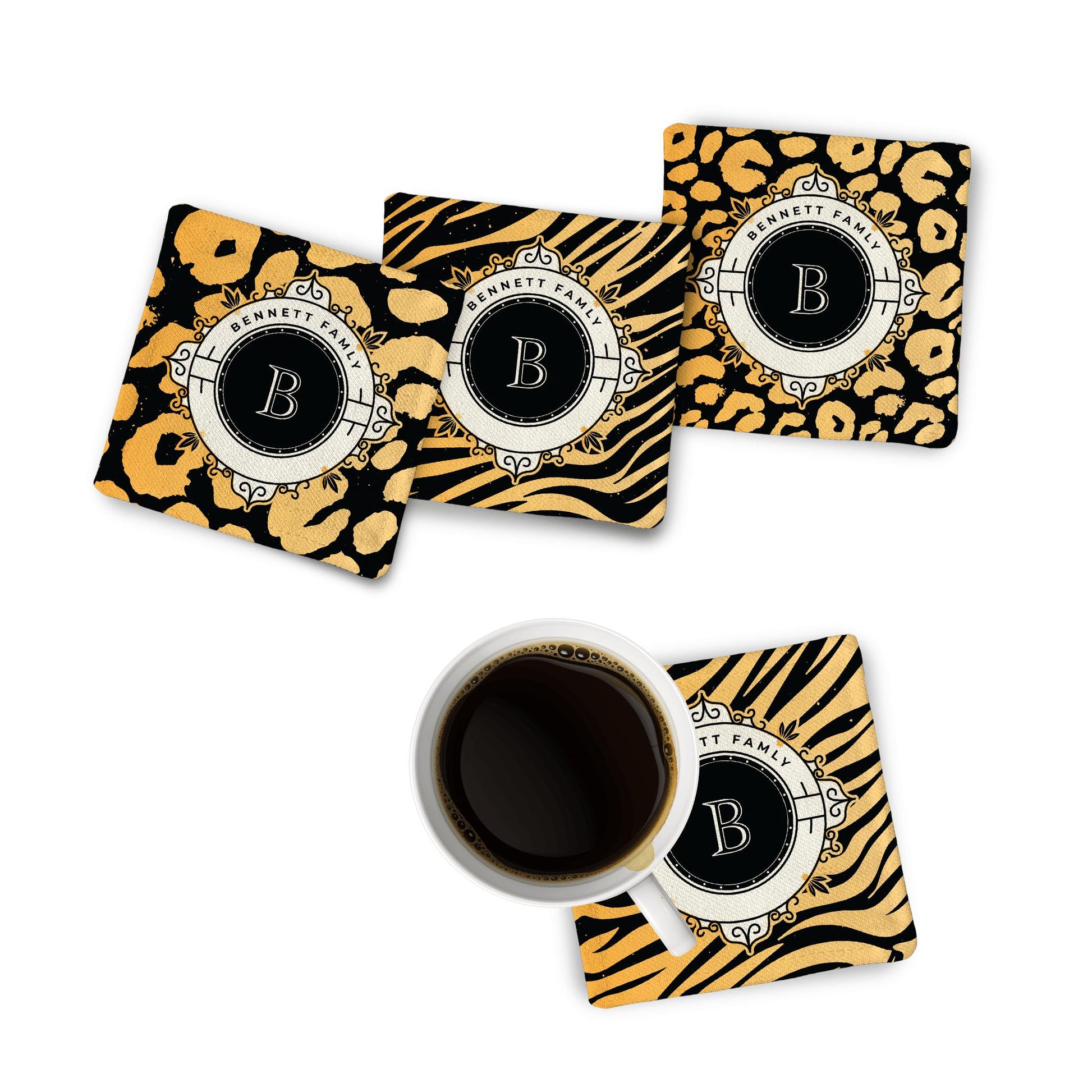 4 Animal Print Monogram Fabric Coasters on white surface with a black coffee mug