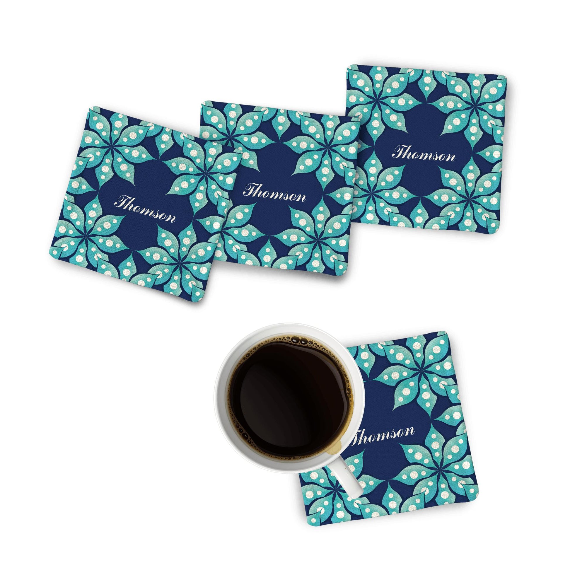 A set of 4 Personalized Fleur Fabric Coasters displayed on a white surface alongside a coffee mug