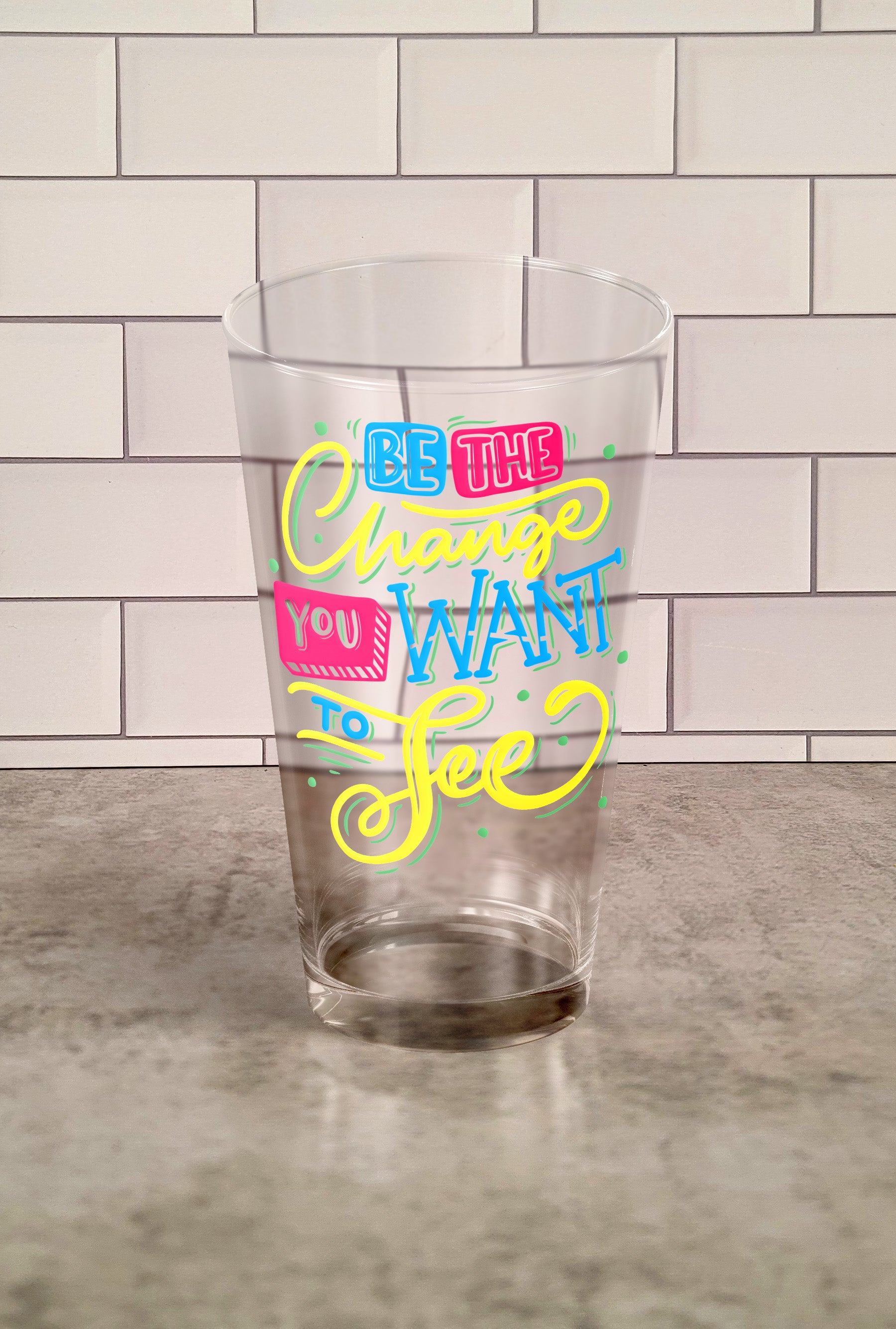 Be The Change You Want To See transparent Tumbler Glass against a slipslap wall