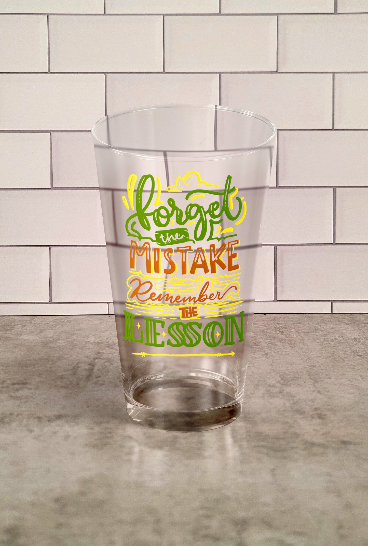 Forget The Mistake Remember The Lesson transparent Tumbler Glass against a slipslap wall