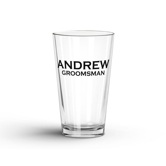 A tranparent Glass Tumbler with Personalized name 'Andrew' and 'groomsman' printed on a white surface