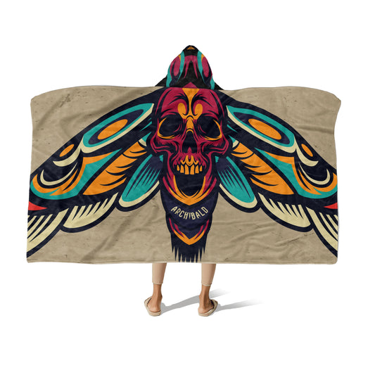 A person wearing a multi-color hooded blanket with Moth wings & skull design and the name "Archibald" at the center-bottom on a white background.