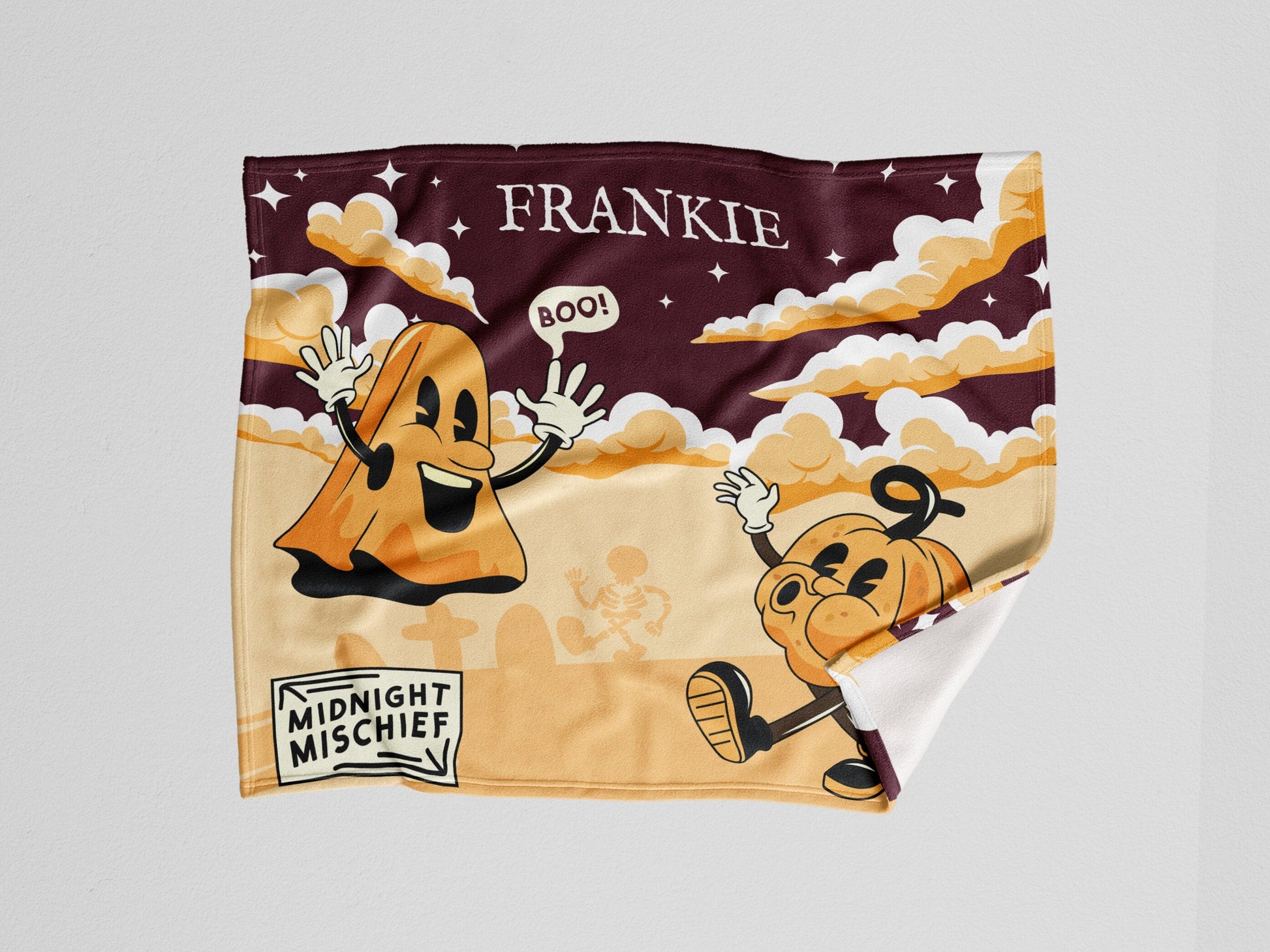 A throw blanket with a playful midnight mischief design, featuring whimsical ghosts, pumpkins, cloud and sky in vibrant colors.