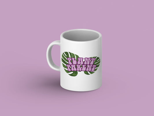 White ceramic mug with "Plant Parent" printed in bold green letters, surrounded by various plant illustrations.