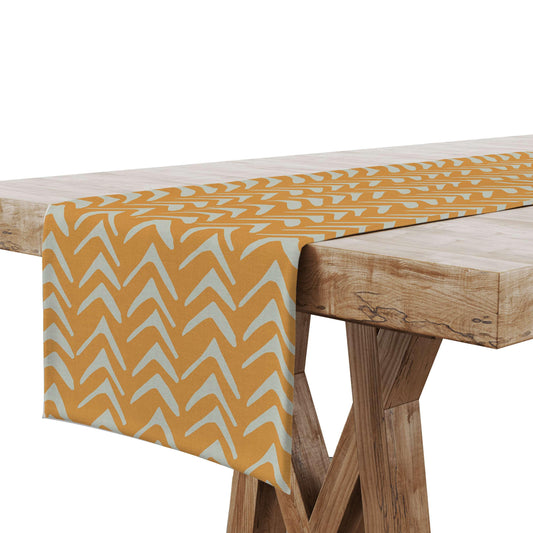 A Mustard color Tribal Table Runner displayed on a wooden surface