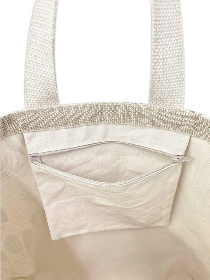 A close-up of a cotton tote bag, the inner pocket is visible