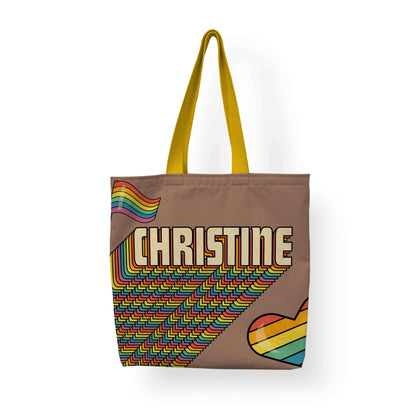 An LGBTQ Pride Retro Tote with yellow handle on a white background and a printed name 'Christine'